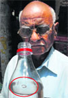 A man shows a reptile (circled) which was found in the drinking water supply in Sector 7,Panchkula, on Friday. Tribune Photo: Nitin Mittal 