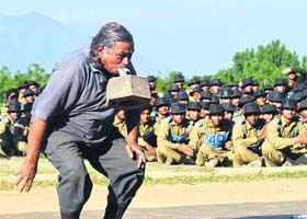 S K Chaudhary, Sports Officer of Andaman & Nicobar, former SDM of Odisha and a Guinness book record holder, lifts 20 kg of weight with his teeth at the BSF campus, Humhama, Srinagar, on Friday