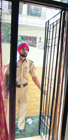 A policeman stands outside the house which was burgled in Amritsar on Saturday.