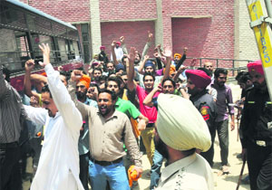 Teachers, who were brought from the Faridkot jail, raise slogans against the Punjab Government after being produced in a court in Bathinda on Saturday. 