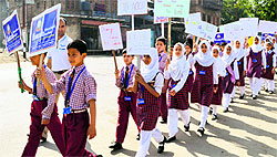 Schoolchildren hold placards during an anti-tobacco rally in Srinagar on Saturday