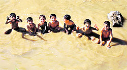 Children bathe in a stream at a village on the outskirts of Srinagar