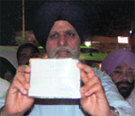 Mayor Harcharan Singh Gohalwaria shows the permission slip issued by an Akali MLA to a vendor in Ludhiana on Friday. A Tribune Photograph 