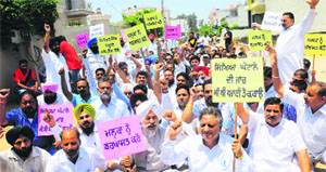 Congress workers protest outside the residence of Education Minister Sikander Singh Maluka in Kansal village, near Chandigarh, on Saturday. 