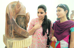 Visitors have a look at a sculpture during an exhibition in Amritsar on Sunday. 