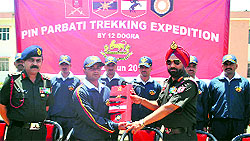 Lt-General NS Ghei hands over a flag, meant to be hoisted on the 5,319-metre-high Pin Parbati pass, to the leader of a trekking team in Fazilka