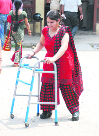 A polio-afflicted woman comes out of a polling booth in Sector 20.