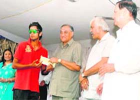 Uttarakhand Chief Minister Vijay Bahuguna presents a cheque for Rs 50,000 to Pramod Chandel who was adjudged "Man of the tournament" in the 31st All-India Uttarakhand Gold Cup cricket Tournament in Dehradun on Sunday