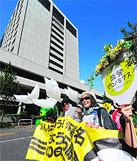Japanese authors Kenzaburo Oe and Keiko Ochiai lead a march to protest against nuclear power plants in Tokyo on Sunday