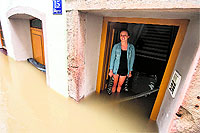 A woman stands at the flooded entrance of a house in Passau city, southern Germany, on Saturday. Due to heavy and ongoing rain, parts of the southern state of Bavaria have been flooded