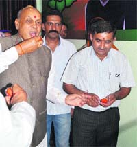 Former Chief Minister PK Dhumal being offered sweets after the inauguration of a BJP office in Hamirpur