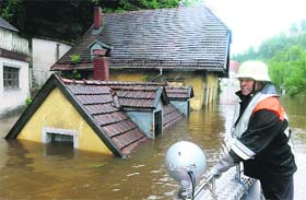 A rescuer navigates through an overflooded street in Passau, southern Germany, on Monday