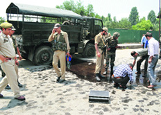 Policemen inspect the site where a grenade was hurled at an Army vehicle in Anantnag