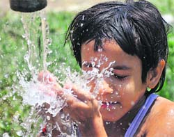 Cool splash: A child splashes water on her face to beat the heat in Jammu on Tuesday. 