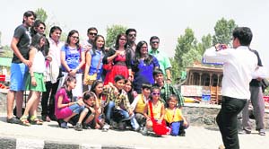 A group of tourists poses for a photograph on the banks of the Dal Lake in Srinagar on Tuesday. 