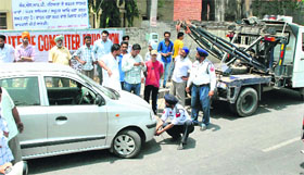 Traffic police impounds a car parked at a no parking zone in Patiala on Tuesday.