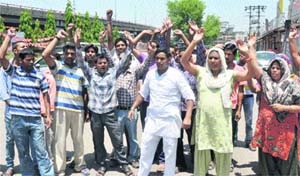 Contractual employees of the Jammu Municipal Corporation stage a protest in Jammu on Wednesday