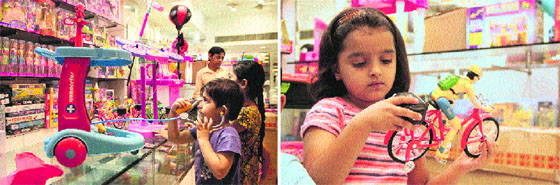 A boy checks out a doctor set at a mall in Jalandhar; a girl having a look at a toy cycle at a mall.