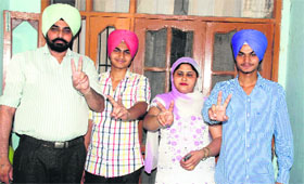 Jagdev Kaur and the members of her family flash the victory sign in Ludhiana.