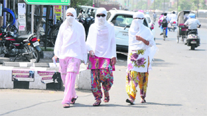 Girls cover themselves before venturing out in Bathinda on a hot and humid Thursday morning. The city witnessed slight rains in the afternoon.