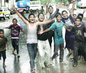 Children enjoy sudden rainshowers in New Delhi on Thursday.