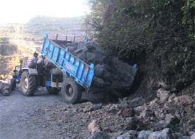 Limestones and sleet being used for the construction of sidewalls of the road and tractor trolleys being filled with excavated stones by contractors on the Mackinnon Cart Road to be used elsewhere