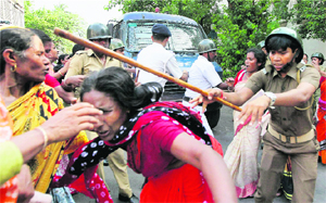 Police personnel rough up midday meal workers during a demonstration in front of the Raj Bhawan in Kolkata on Thursday. 