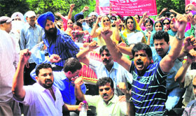 UT employees hold a protest in Chandigarh on Friday.
