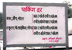 A parking signboard at an MDDA Parking lot shows no rate list