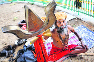 A sadhu holds a trident as he sits in a meditative posture in Jammu on Friday. With the Amarnath yatra beginning on June 28, hundreds of sadhus from various parts of the country have started arriving in the temple city.