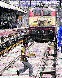 A vendor crosses rail tracks by putting his life in danger as 