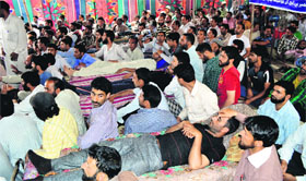 Public Health Engineering Department employees sit on a fast in Srinagar on Friday.