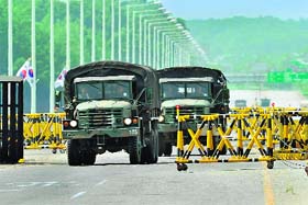 South Korean military trucks drive past barricades on the road linking North Korea's Kaesong Industrial Complex in Paju on Thursday