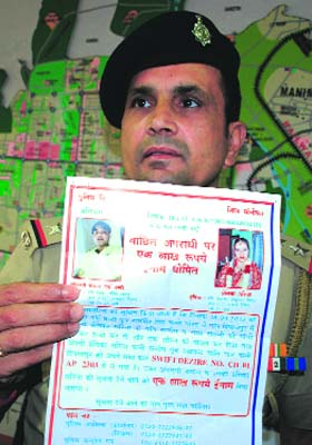 Station House Officer Ram Gopal shows the poster carrying the suspected murderers photograph in Chandigarh on Saturday