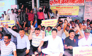 Taxi operators hold a protest against the decision of the railway authorities to shift their taxi stand from the Dehradun railway station on Saturday.