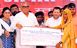 Chief Minister Bhupinder Singh Hooda presents a certificate to a beneficiary of the Priyadarshini Awas Yojna in Karnal on Saturday