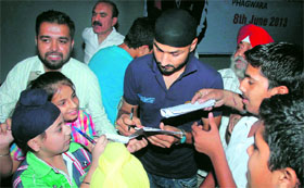 Children take autograph from cricketer Harbhajan Singh at the opening of a sports academy at Cambridge International School in Phagwara on Saturday.
