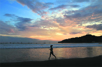 Beach Beauty: A tourist jogs on the beach at San Juan del Sur, Nicaragua, at sunset.