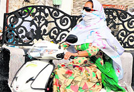 Women cover their faces while venturing out in the hot sun for work in Bathinda on Sunday. With summer showing no signs of relenting, people are resorting to various ways to protect themselves from heat