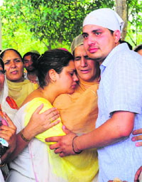Slain Inspector Sucha Singhs wife (centre) flanked by his daughter and son at the cremation ground in Sector 25, Chandigarh, on Sunday.