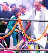 Uttarakhand Chief Minister Vijay Bahuguna presents a bicycle to a girl student at a function at Lal Kuan in the Kumaon region on Sunday.