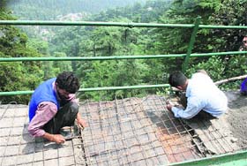 PWD workers repair a pedestrian road in Shimla on Sunday