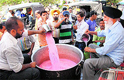 Cooperative Bank employees serve sweetened water to passersby in Jalandhar on Sunday
