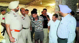 Police officials question a worker of the dyeing factory on the Tajpur road in Ludhiana on Sunday.