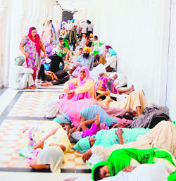 Devotees take rest in a corridor at the Golden Temple in Amritsar on Sunday.