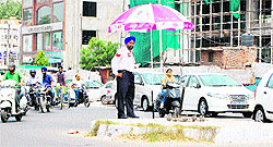 A traffic polceman stands on duty in scorching heat at the Lawrance Road chowk in Amritsar on Monday