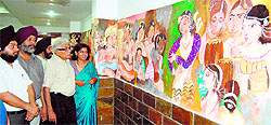 Baldev Gambhir (second from right) and other artists have a look at the painting by Aruna Sharma in Amritsar on Monday