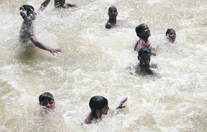 Children swim in Sirhind Canal to get relief from the searing heat in Bathinda on Monday. 