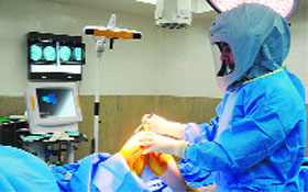 Dr Manuj Wadhwa operates on a patient while wearing a special suit.