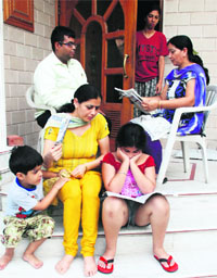 A family sits outside the house to seek relief from heat as there was no power in Sector 12, Panchkula, on Monday.